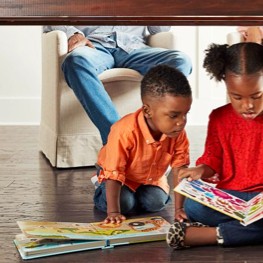 Children look into book sitting On Floor | Ultimate Flooring Design Center